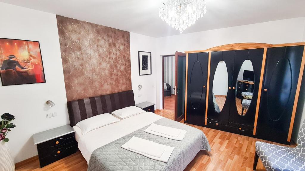 een slaapkamer met een bed en een kroonluchter bij Casa Millelune in Focşani