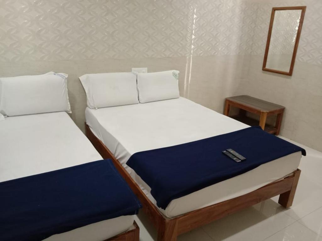 two twin beds in a room with a mirror at Vishnu Bhavan in Tirupati