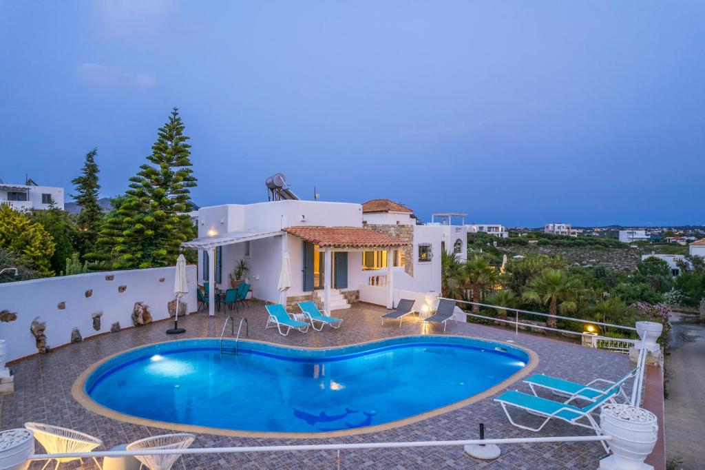 a villa with a swimming pool in front of a house at Seaview Villa Prima, Sea & Sun Villas in Chorafakia