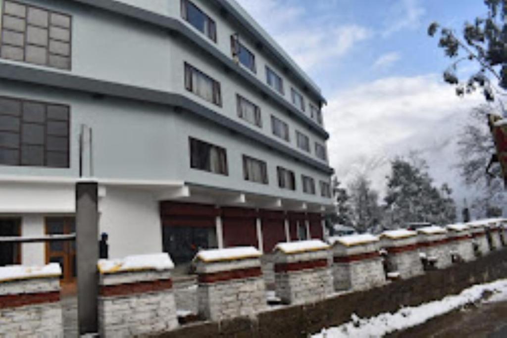 a building with snow on the ground next to it at The Mandala Hotel Dirang in Dirang Dzong