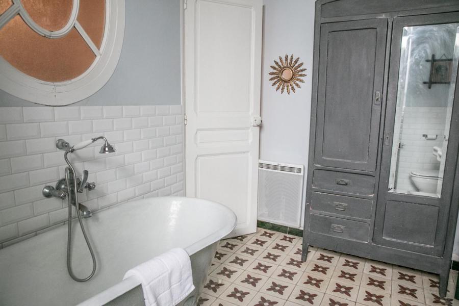 a bathroom with a white tub and a black cabinet at La Petite Calanque in Marseille