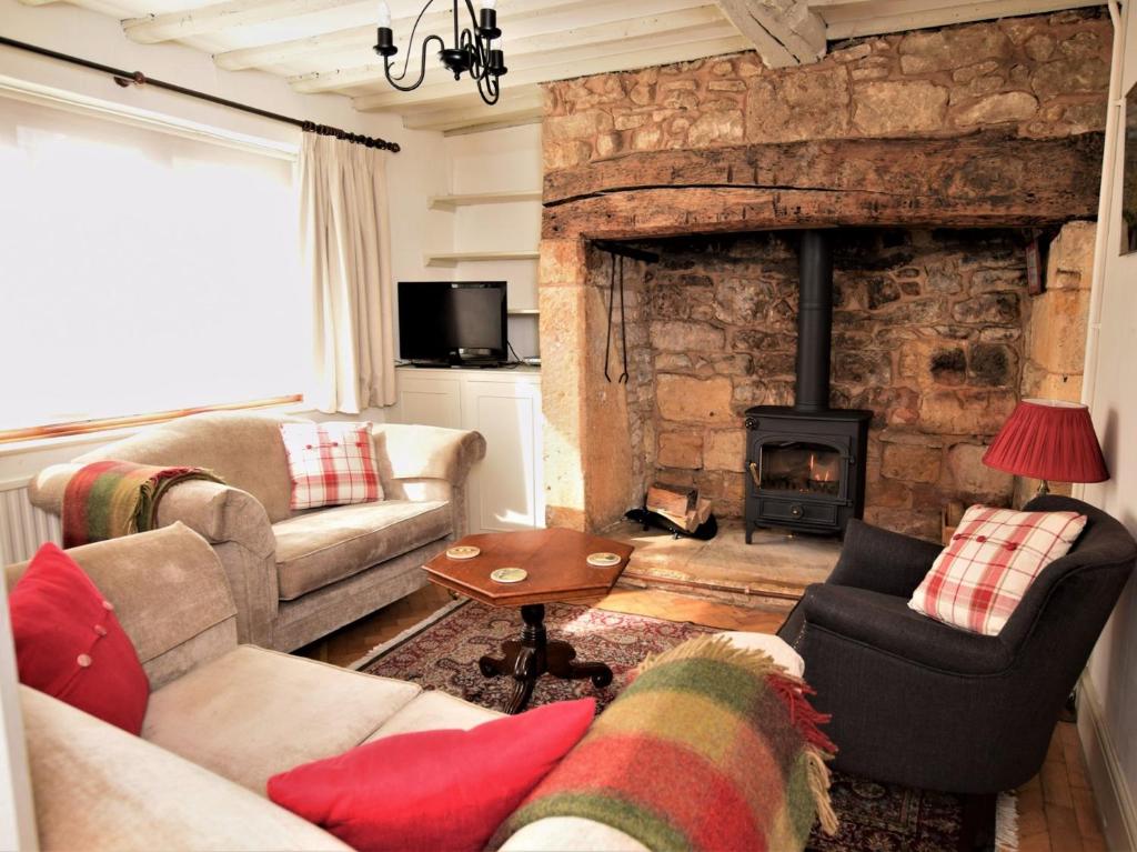 a living room with a couch and a fireplace at 2 Bed in Winchcombe 47951 in Winchcombe