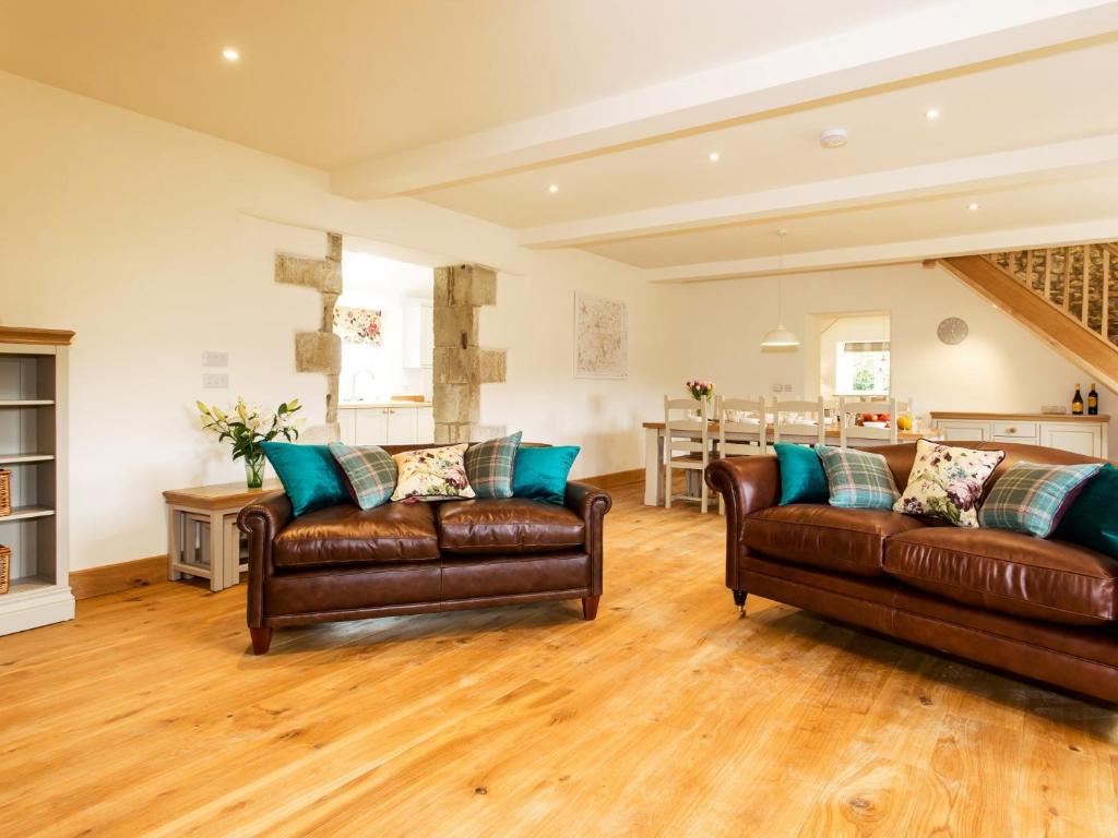 a living room with two leather couches and a kitchen at 3 Bed in Melbury Abbas 48804 in Melbury Abbas