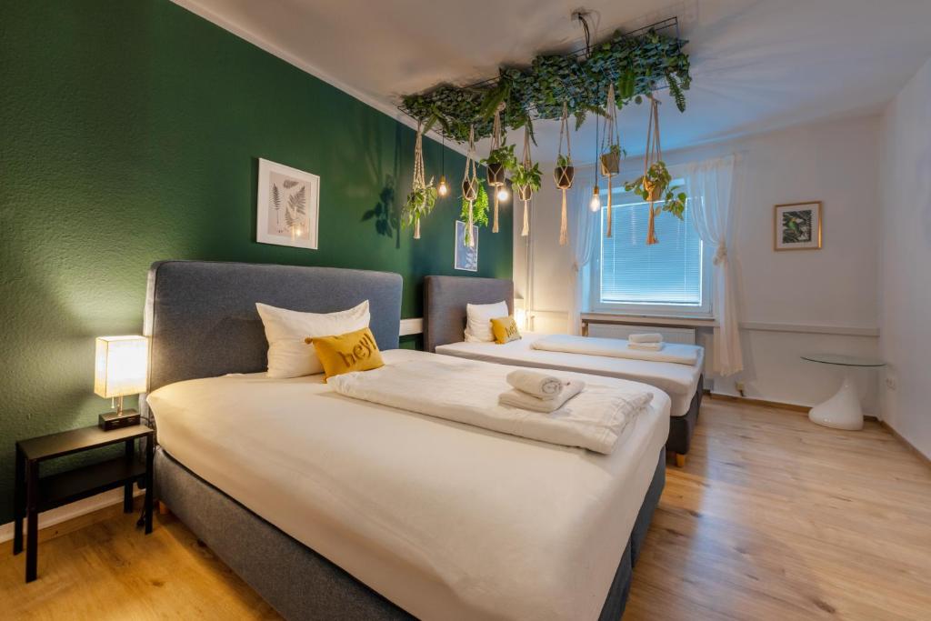 - 2 lits dans une chambre aux murs verts dans l'établissement Stay Awesome - Urban Jungle Apartment Zentral, Wilhelmshöhe, à Cassel
