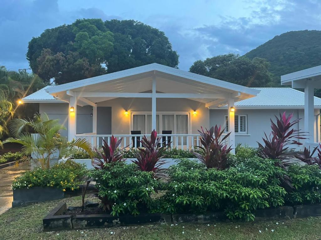 a white house with a porch and trees at The Lane Rodney Bay 1 bedroom rate - Newly renovated & tastefully furnished 3 bedroom house home in Rodney Bay Village