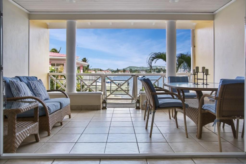 a patio with a table and chairs and a view of the ocean at The Harbour #6 - 2 Bedrooms in Rodney Bay townhouse in Gros Islet