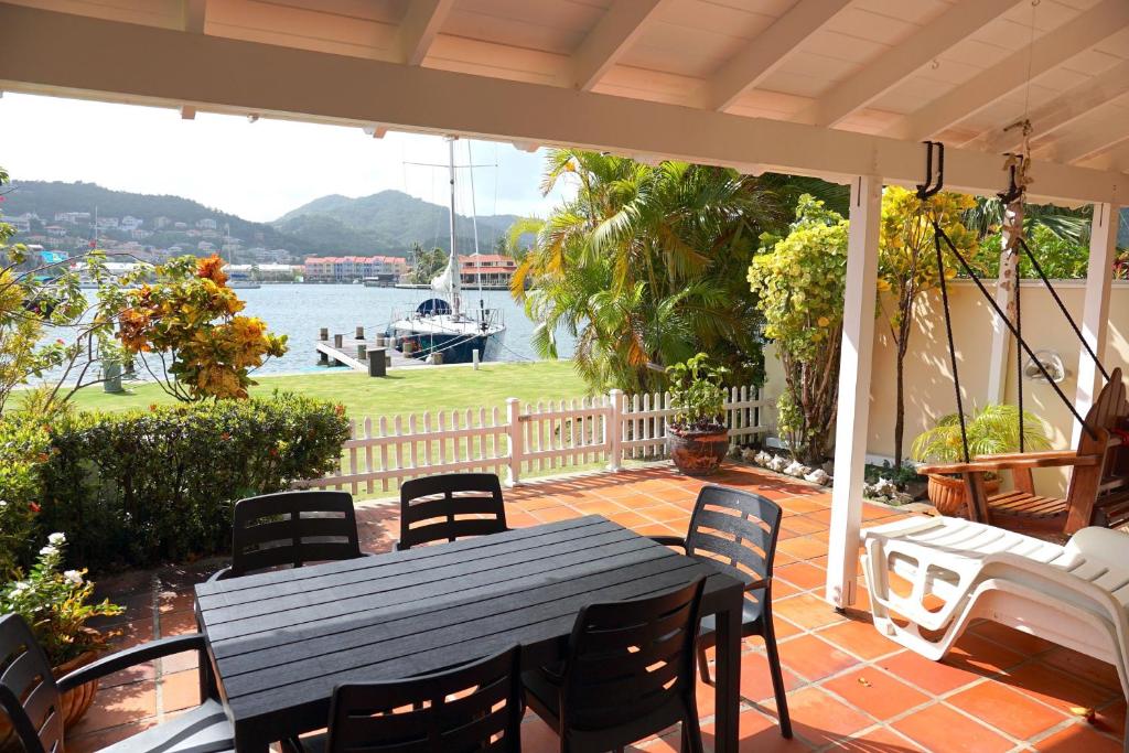 a table and chairs on a patio with a view of the water at Admiral's Quay #5 - Comfortable Townhouse townhouse in Rodney Bay Village