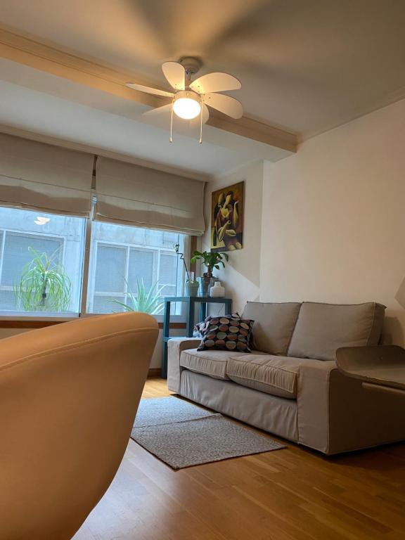 a living room with a couch and a ceiling fan at Moderno apartamento con encanto en el centro de Vigo in Vigo