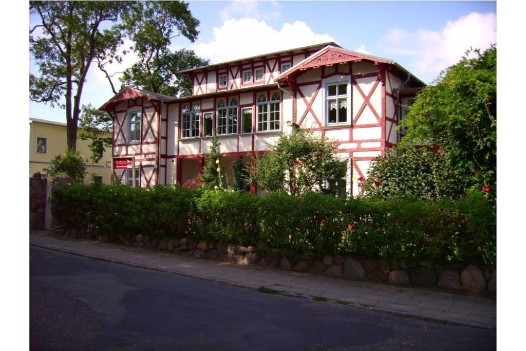 een rood-wit huis in een straat bij Villa Gundula nur 600m bis zum Ostseestrand in Zinnowitz