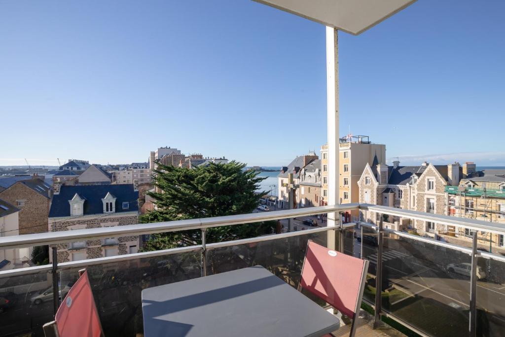 d'un balcon avec des chaises et une vue sur la ville. dans l'établissement Le Petit Malouin - Appartement proche plage, à Saint-Malo