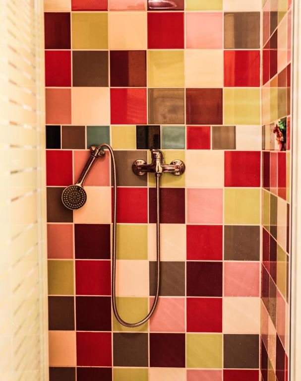 a bathroom with a shower with a colorful tiled wall at La Petite Calanque in Marseille