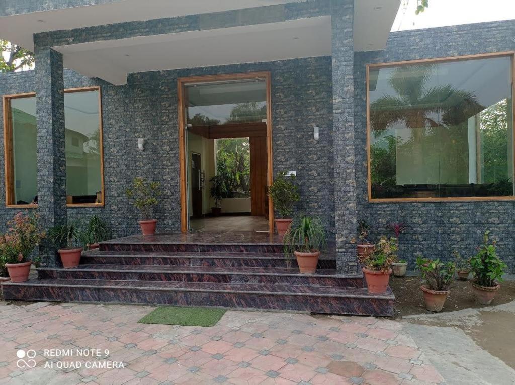 a brick house with stairs and potted plants at Royals Moonlight Resort,Corbett in Rāmnagar