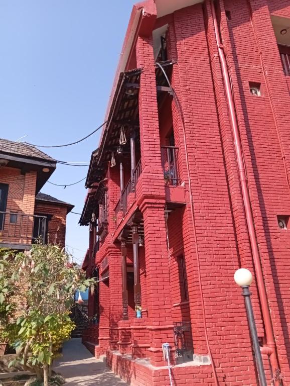 un edificio de ladrillo rojo con balcón en una calle en Hotel Mountain Ridge en Bandipur