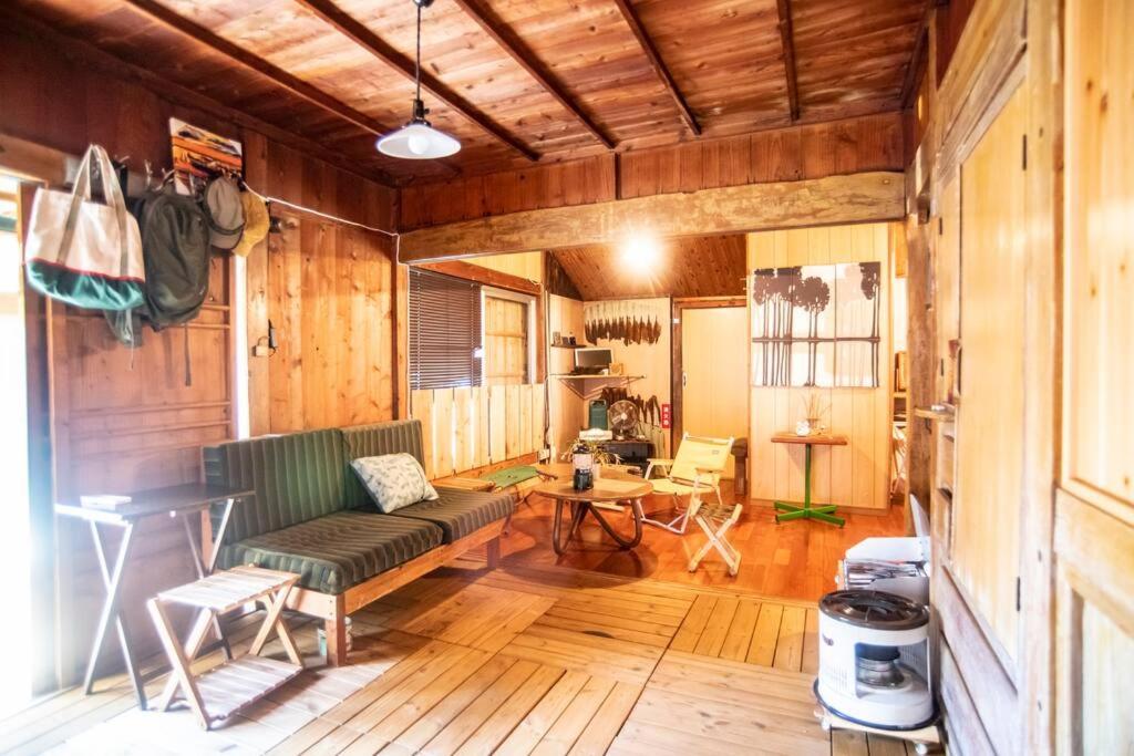 sala de estar con sofá y mesa en 【Camp House by port Side】 貸切1組の古民家/離島、美ら海への拠点, en Motobu