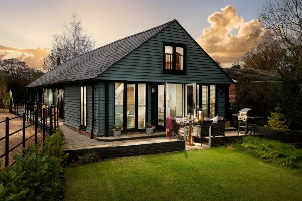 ein grünes Haus mit einer Veranda und einer Liegewiese in der Unterkunft The Cart House in Southampton
