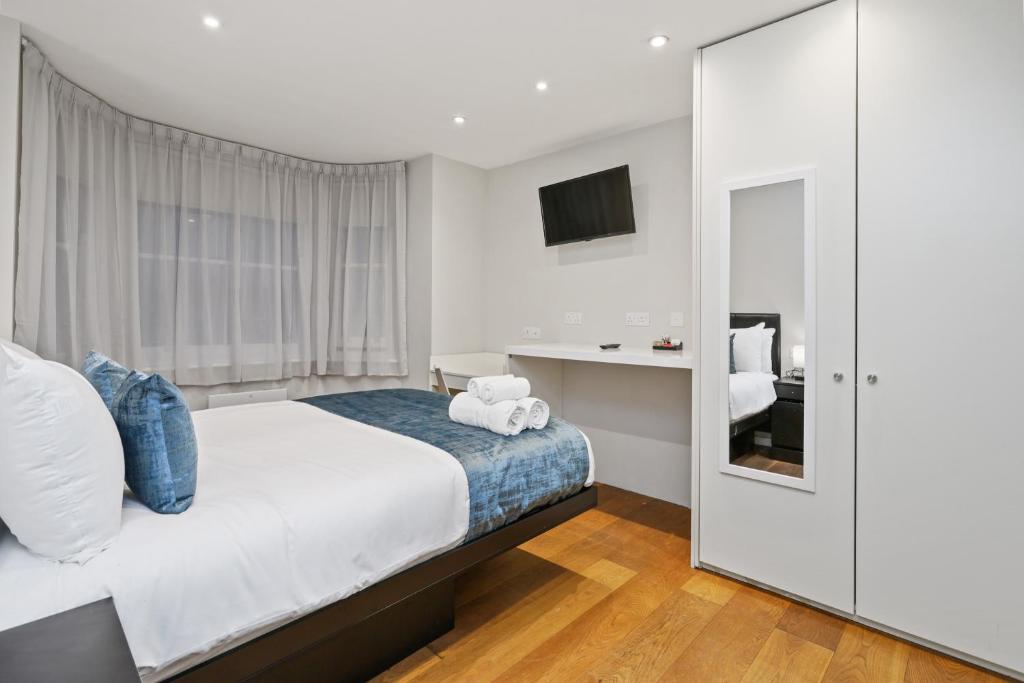 a bedroom with a bed with a teddy bear on it at Private Studio Flat in London