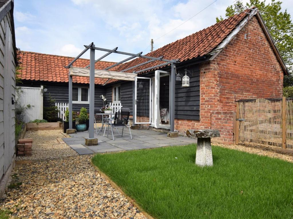 a brick house with a garden and a patio at 1 bed property in Mattishall 57021 in Mattishall