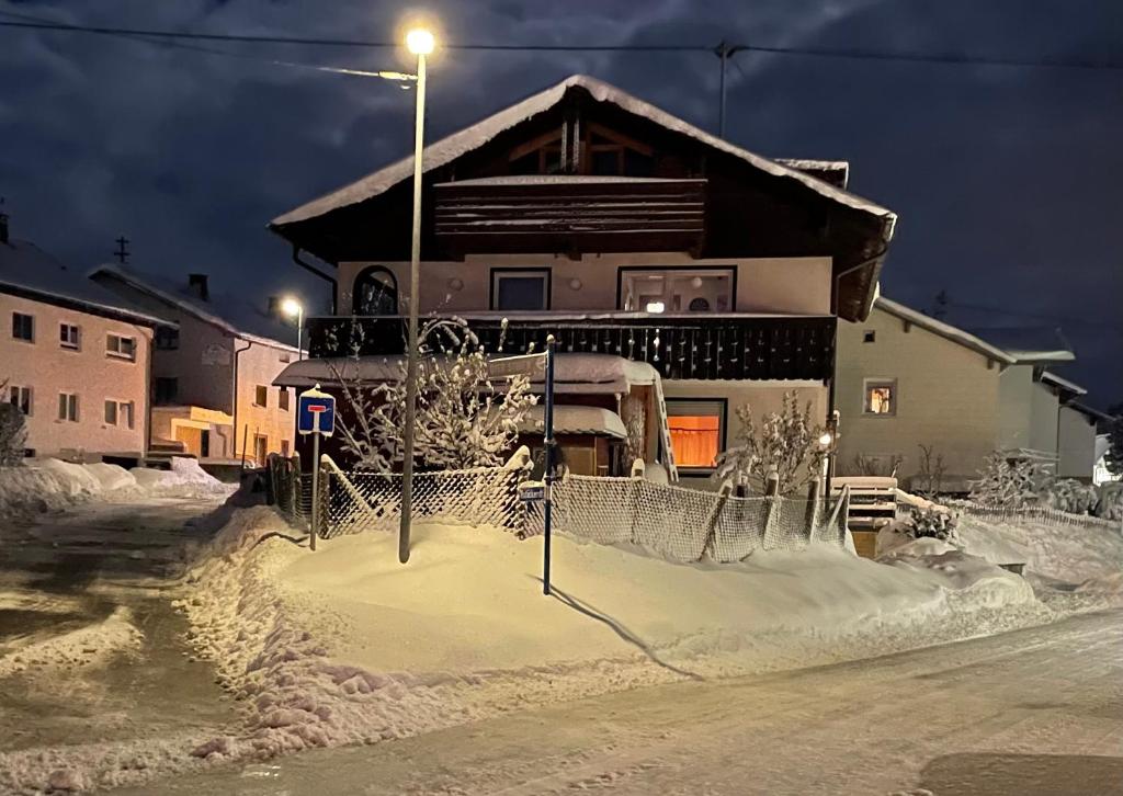 a house is covered in snow at night at Straub / Ferienwohnung Allgäublume in Oy-Mittelberg