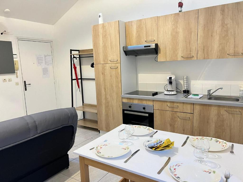 une cuisine avec une table avec des assiettes dessus dans l'établissement Le Mollien, à Calais