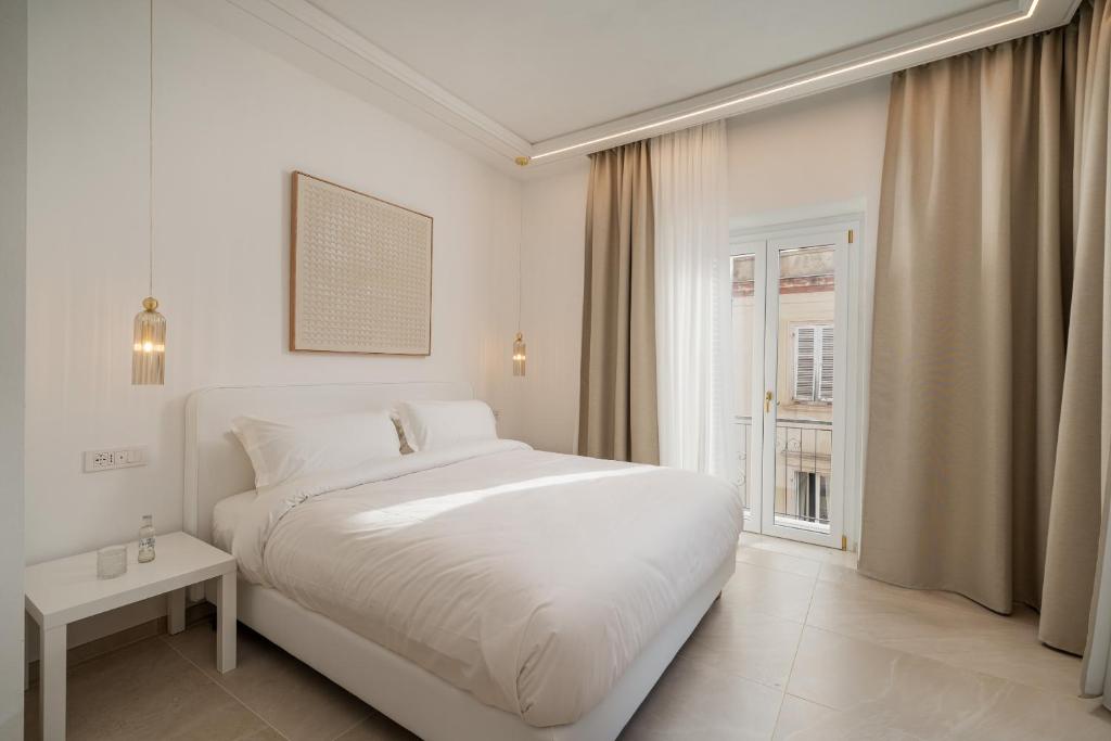 biała sypialnia z białym łóżkiem i oknem w obiekcie Unico w mieście Sassari