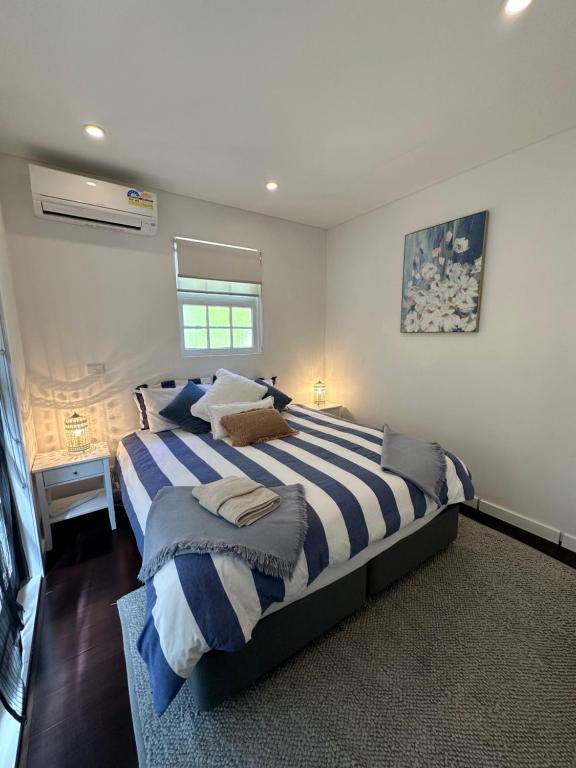 a large bedroom with two beds and a window at Kookaburra Cottage in Bowral