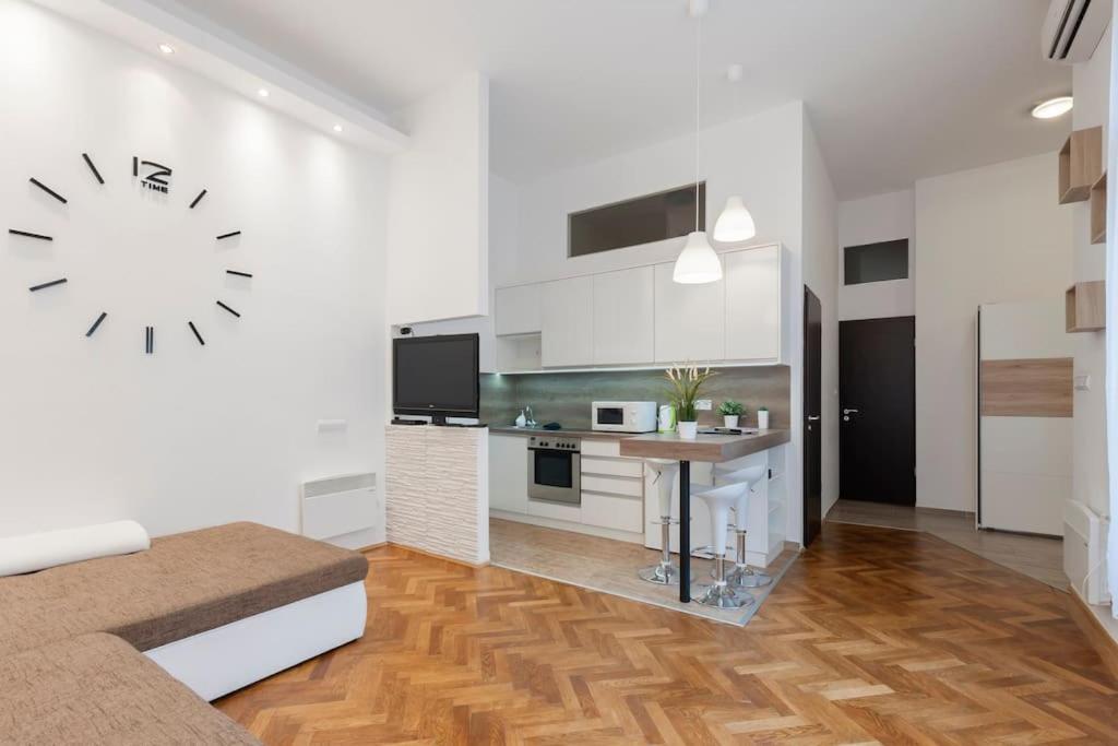 a white living room with a clock on the wall at Szent Istvan ter 4 Next to Basilica a 1 BedRoom in Budapest