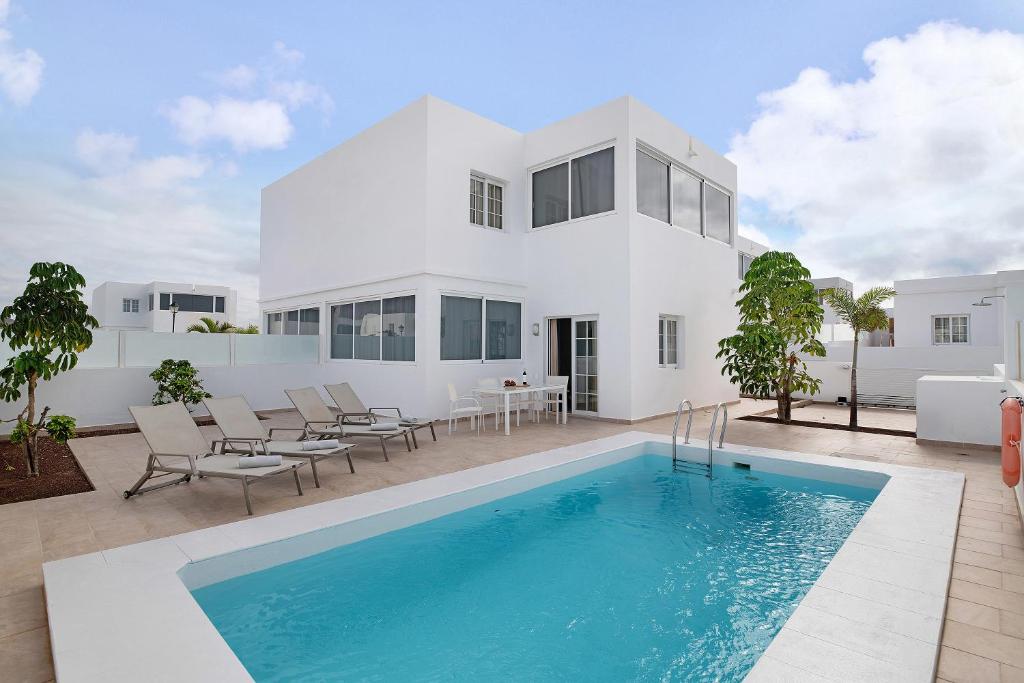 a white house with a swimming pool in front of it at Villa Khaleesi in Playa Blanca