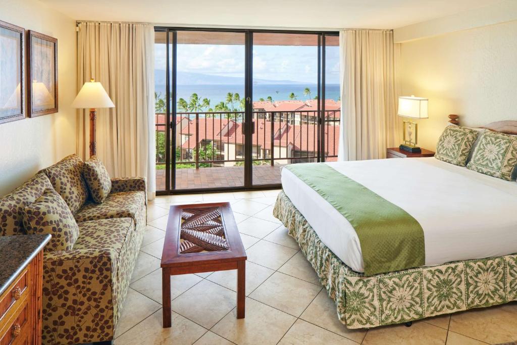 una habitación de hotel con una cama y un sofá en Aston Kaanapali Shores, en Lahaina