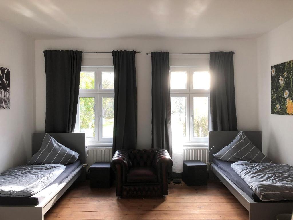 a room with two beds and a chair and windows at NEU! Ferienidyll Nähe Plauer See in Halenbeck
