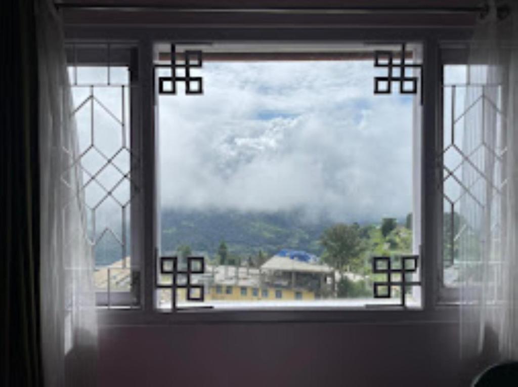 a window with a view of a building at Hotel Mon Paradise, Tawang in Tawang