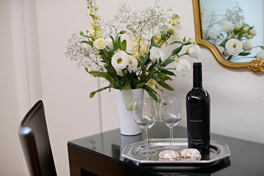 a table with a bottle of wine and two glasses at Venere B&B in Catania