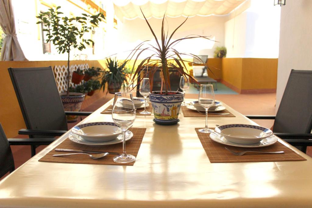 un tavolo con piatti e bicchieri da vino sopra di Duplex acogedor con gran terraza en pleno centro de Sevilla! a Siviglia