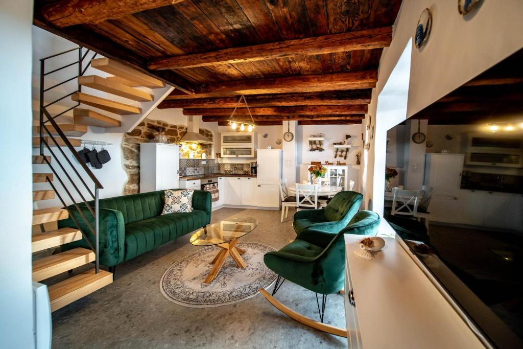 House Filumena في لوبار: غرفة معيشة مع أريكة خضراء وطاولة