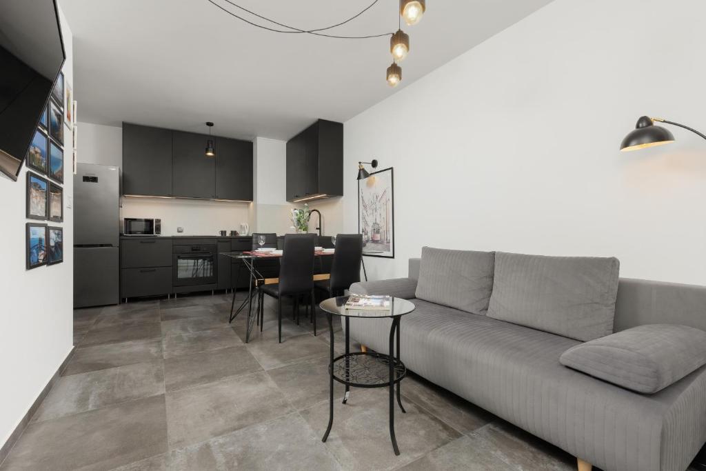 a living room with a couch and a kitchen at Black & White Minimalist Apartment in Warsaw by Renters in Warsaw