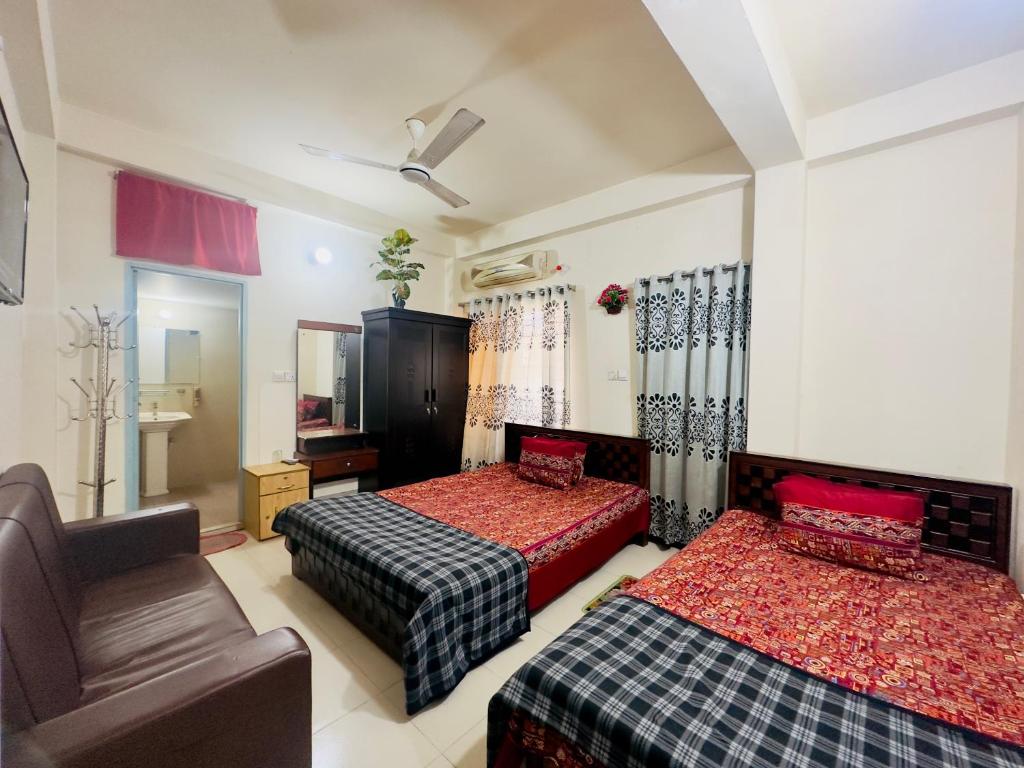 een slaapkamer met 2 bedden en een bank bij Appayan Guest House Baridhara (Bhagyakula Building) in Dhaka