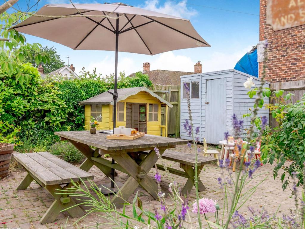 a picnic table with an umbrella in a garden at 2 Bed in Horsted Keynes 60405 in Horsted Keynes
