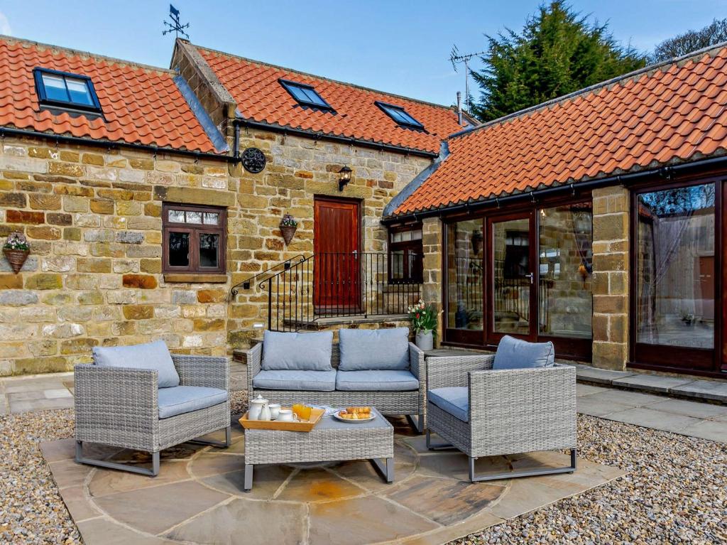a patio with wicker chairs and a table at 2 Bed in Osmotherley 64413 in Osmotherley