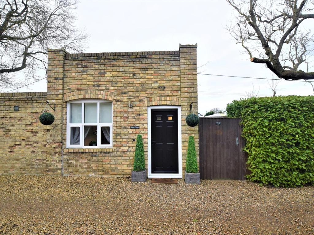 une maison en briques avec une porte noire et une clôture dans l'établissement 1 bed in Beccles 65080, à Beccles