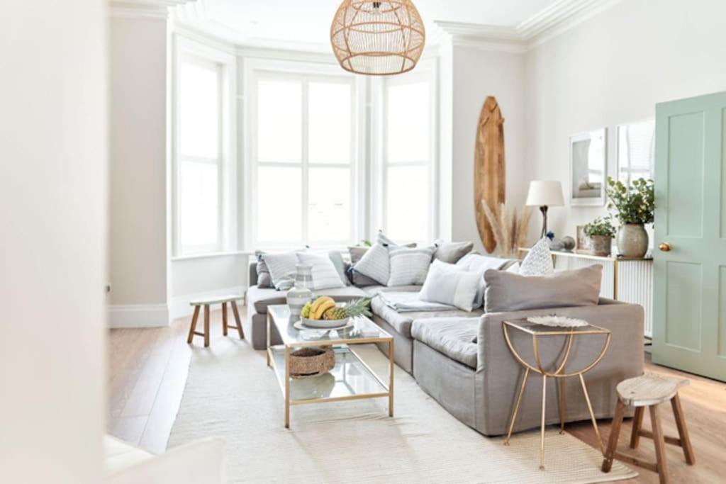 a living room with a couch and a table at The Beach House Sleeps 20 & 4 mins to the beach in Bournemouth