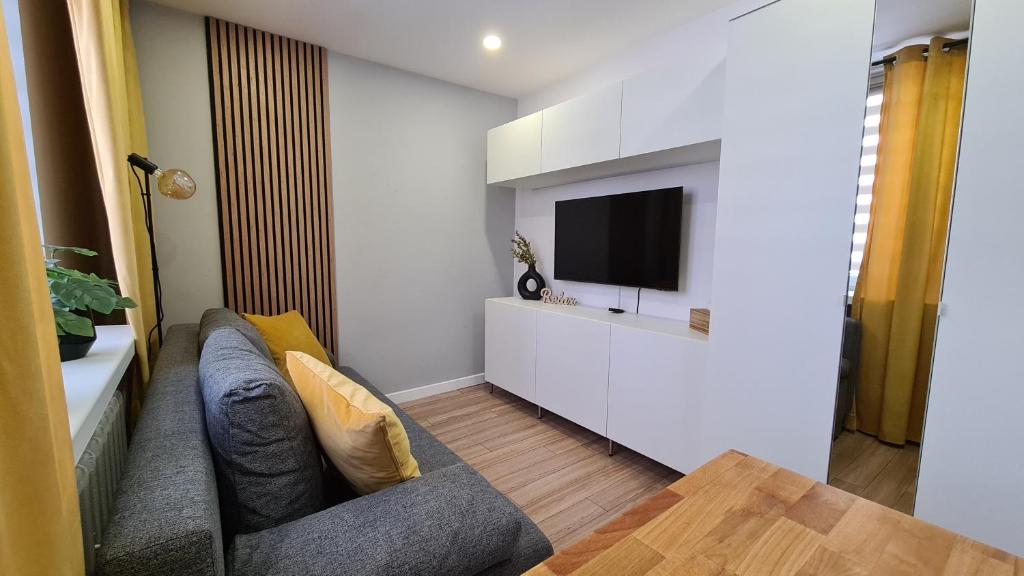 a living room with a couch and a tv at Apartament SECONDO 