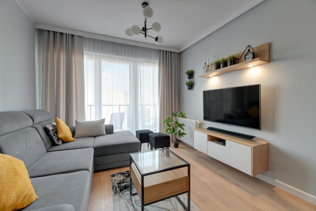 un soggiorno con divano e TV di NORDBYHUS Apartamenty Seaside Baltea Park a Danzica