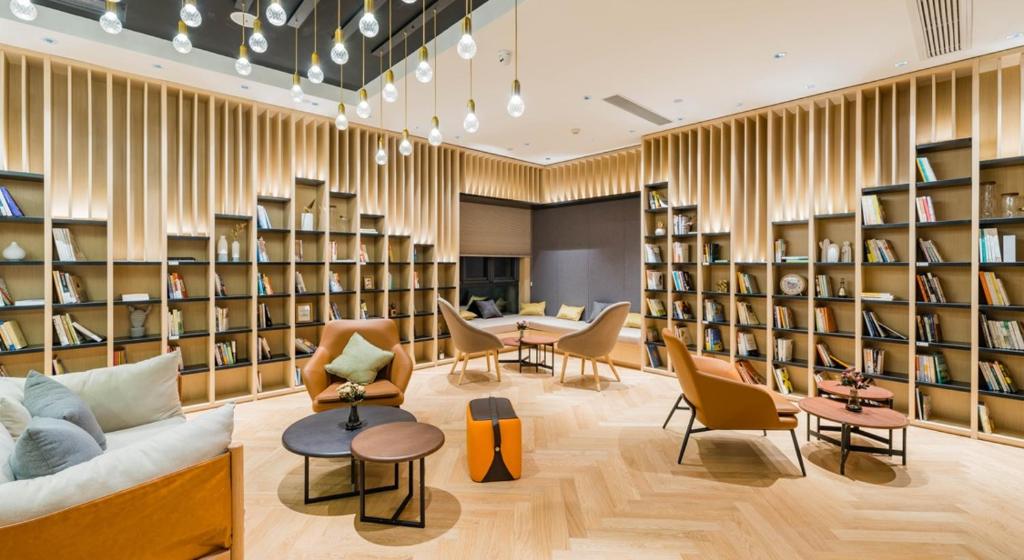 une bibliothèque avec des étagères, des tables et des chaises dans l'établissement Atour Hotel Zhejiang University East Fengqi Road, à Hangzhou