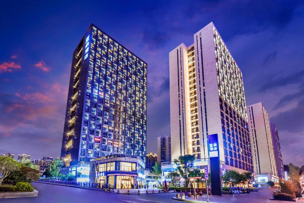 zwei hohe Gebäude in einer Stadt in der Nacht in der Unterkunft Atour Hotel Guiyang Convention and Exhibition Center in Guiyang