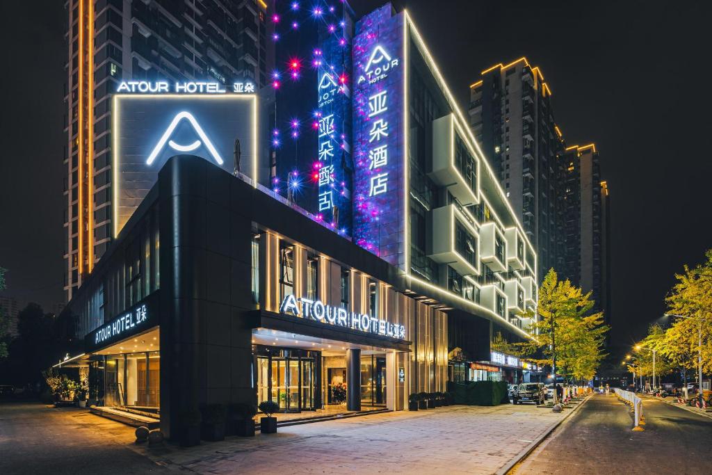 a building with a sign on the side of it at night at Atour Hotel Huzhou Dongwu in Huzhou