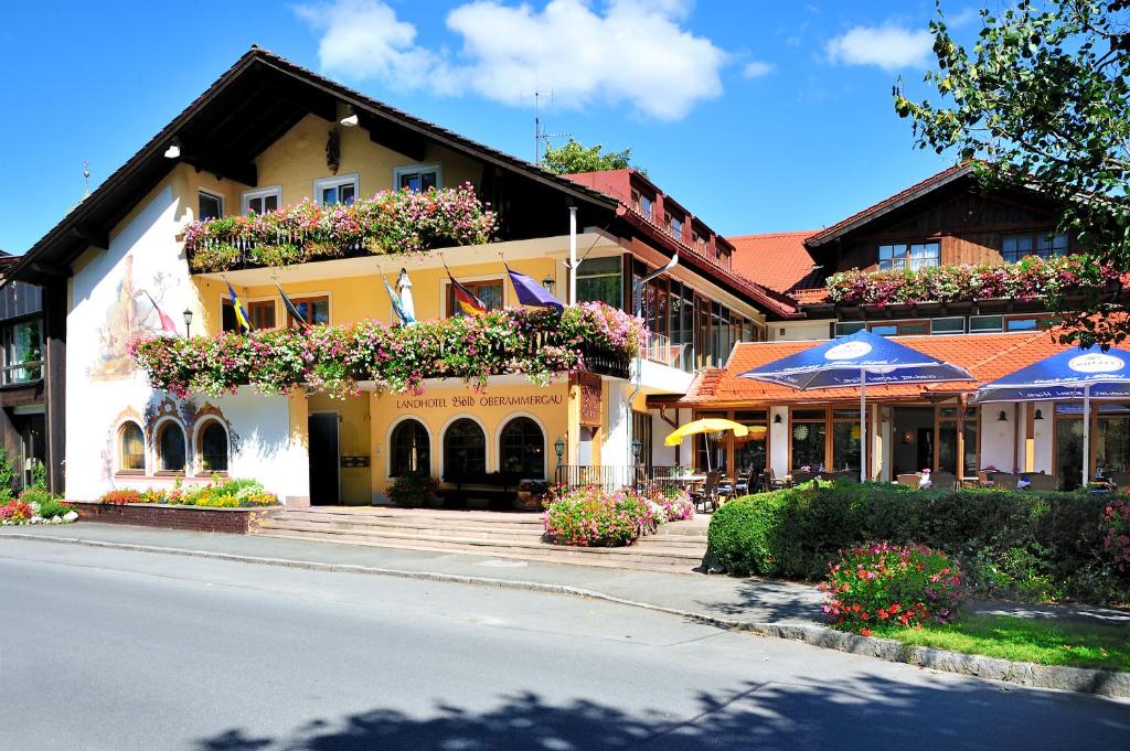 a building with flowers on the side of a street at Landhotel Böld Oberammergau in Oberammergau