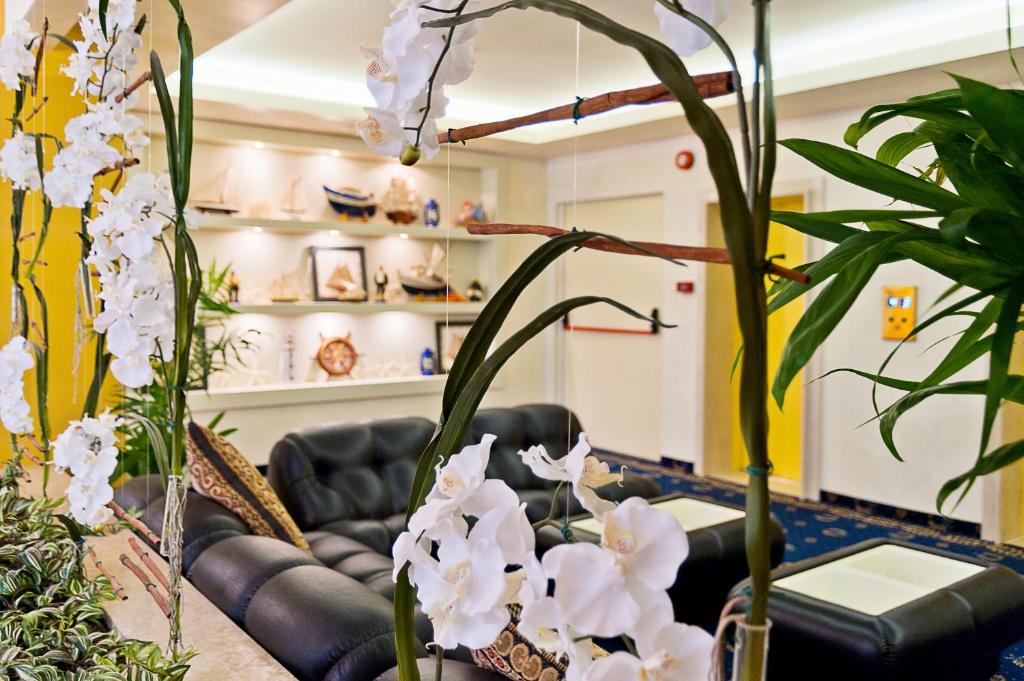 a living room with a couch and some plants at Hotel Montecarlo in Bibione