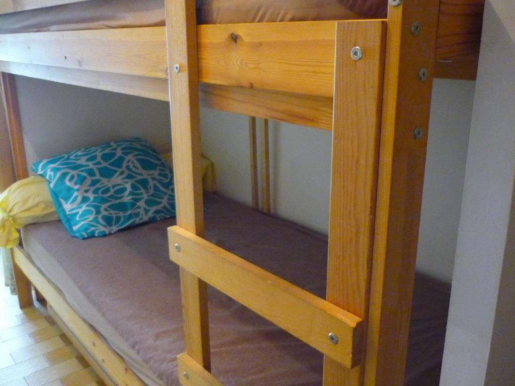 - un lit superposé en bois avec un oreiller bleu sur le lit inférieur dans l'établissement MER indigo & FLAMANTS Roses, à Mauguio