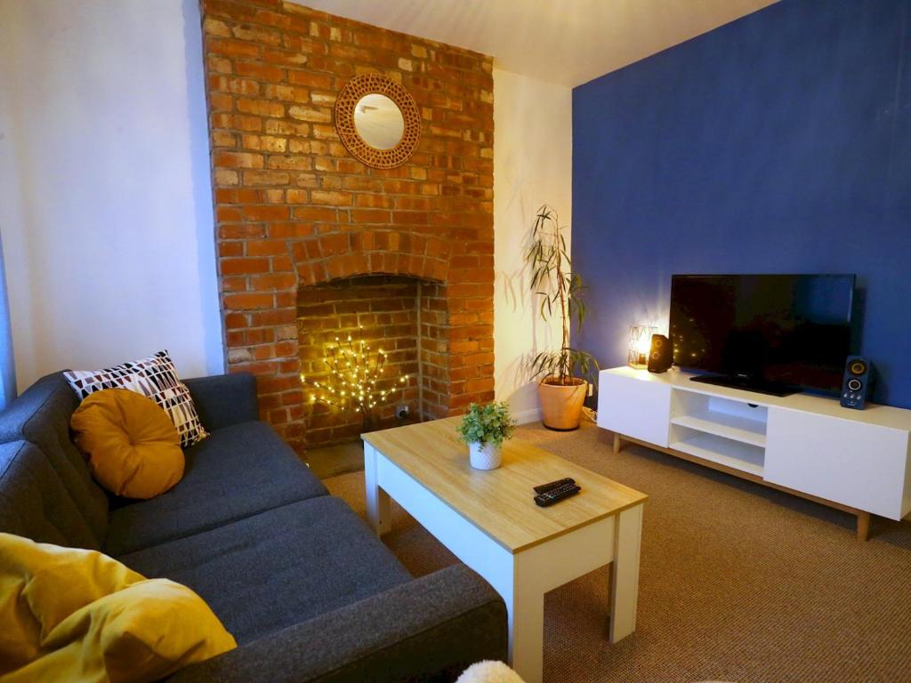 uma sala de estar com um sofá e uma lareira em Pass the Keys King Bed House Next To Heaton Park WM Discounts em Manchester