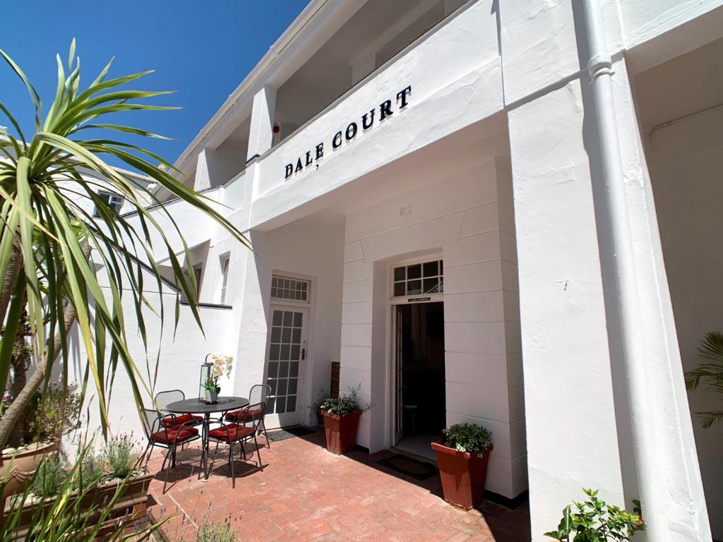 a white building with a table and chairs at Dale Court Guest House in Cape Town