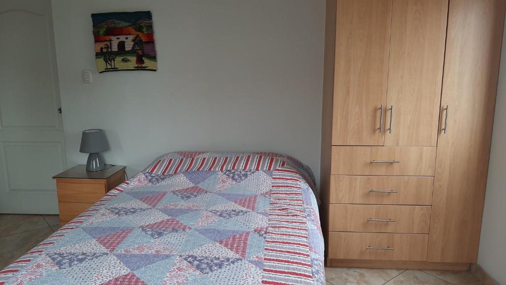 a bedroom with a bed and a wooden cabinet at Terraza más habitaciones en La Molina in Lima